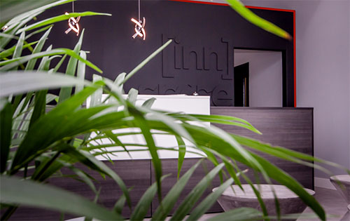 Innspace front reception area from behind a lush green plant.