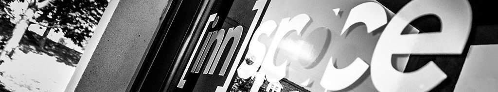 innspace logo on the front door of the building. Close up and angled in black and white.